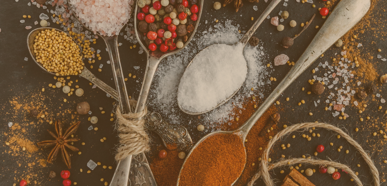 5 spoons on table filled with spices